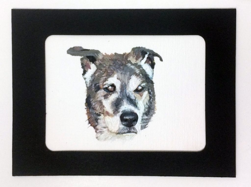 a brown and black dog face painted on paper canvas in a black frame